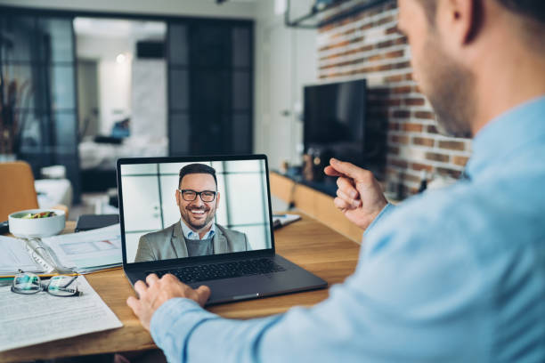 Un professionnel échange en visioconférence avec son coach depuis son ordinateur portable